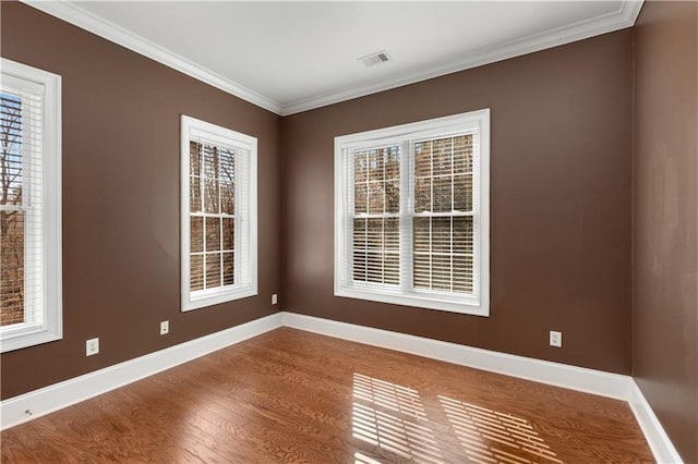 empty room featuring crown molding and hardwood / wood-style flooring