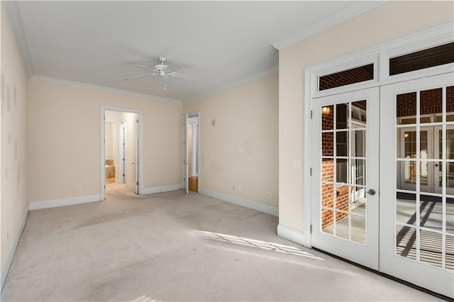 empty room featuring french doors, ceiling fan, crown molding, and light colored carpet