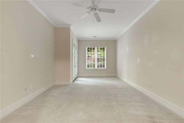 empty room featuring light colored carpet, crown molding, baseboards, and a ceiling fan