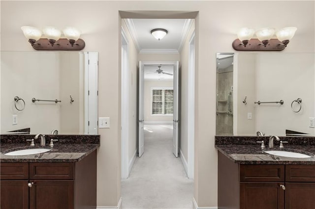 bathroom featuring crown molding, baseboards, two vanities, and ceiling fan