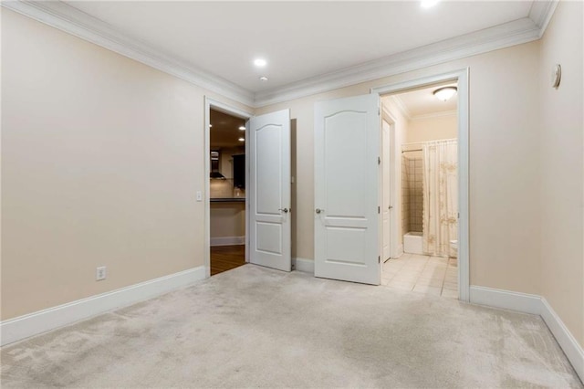 unfurnished bedroom with crown molding, carpet flooring, baseboards, recessed lighting, and ensuite bath