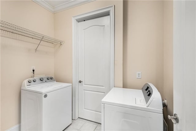 laundry room featuring separate washer and dryer, crown molding, and light tile patterned floors