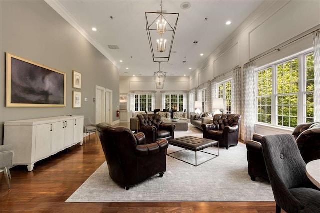 living area featuring dark wood-type flooring, a chandelier, crown molding, and recessed lighting