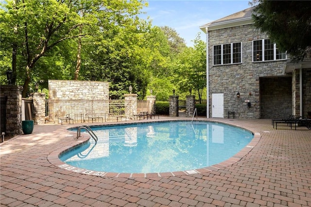 community pool featuring a patio area and fence