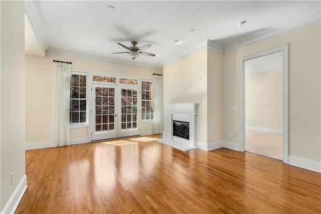 unfurnished living room with crown molding, ceiling fan, light hardwood / wood-style floors, and french doors