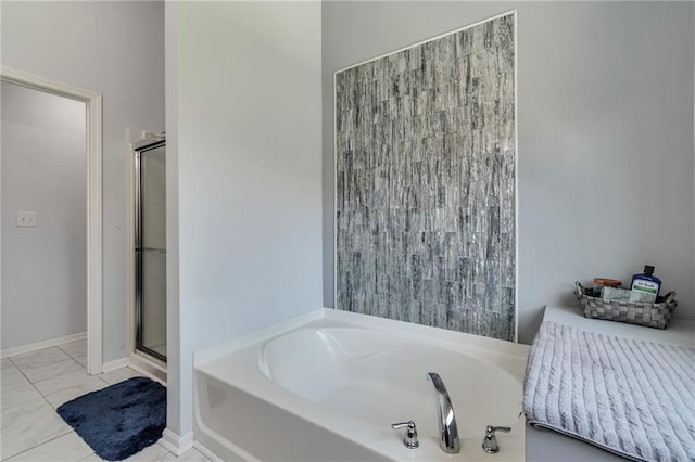 full bathroom with marble finish floor, baseboards, a garden tub, and a shower stall