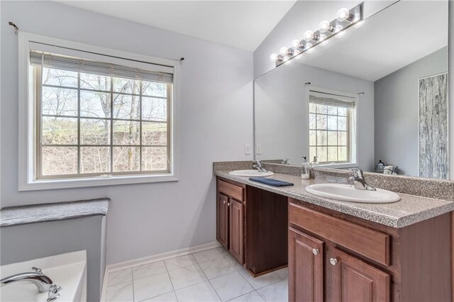 bathroom featuring double vanity, a sink, baseboards, and vaulted ceiling