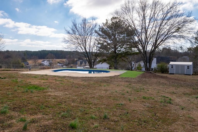 view of yard featuring a patio area, a storage shed, and an empty pool