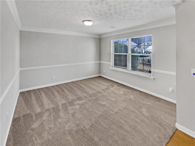 carpeted empty room featuring crown molding and a textured ceiling