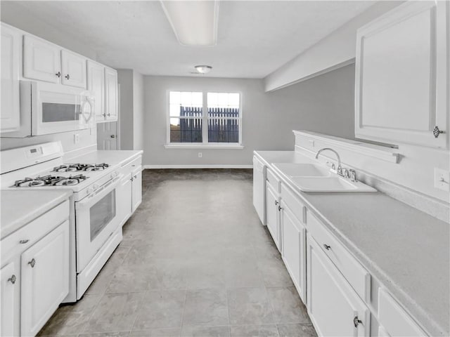 kitchen with sink, white appliances, and white cabinets