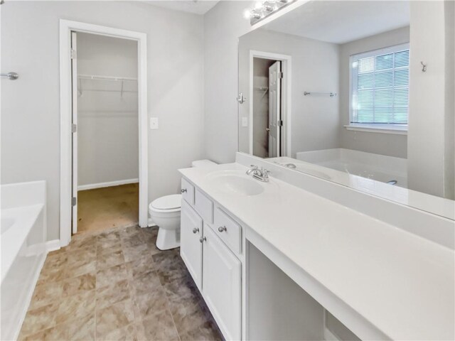 bathroom featuring vanity, toilet, and a tub