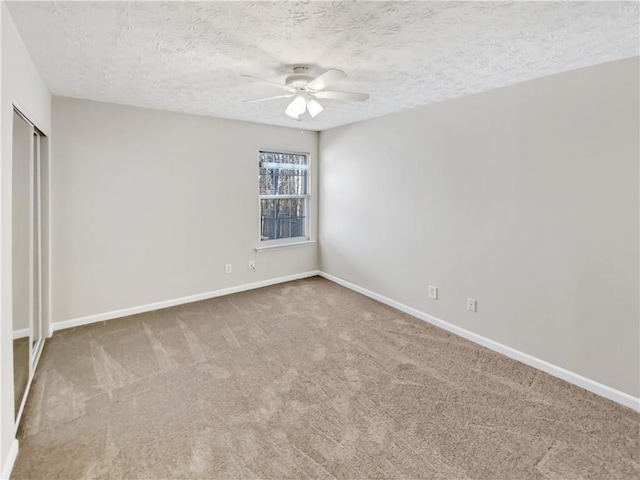 spare room featuring carpet floors, a textured ceiling, and ceiling fan