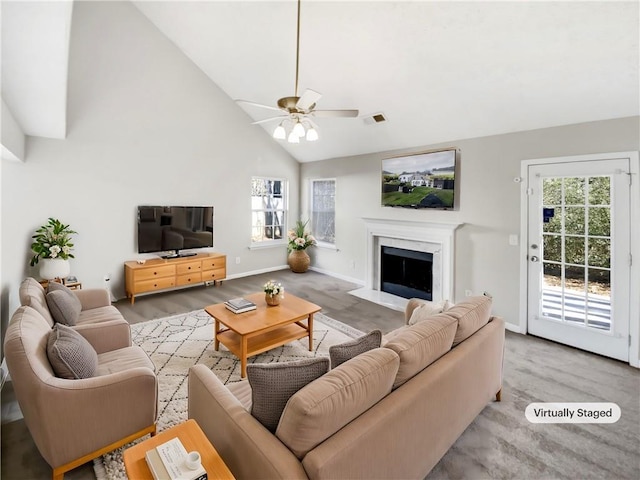 living room featuring ceiling fan, light wood-type flooring, a premium fireplace, and high vaulted ceiling