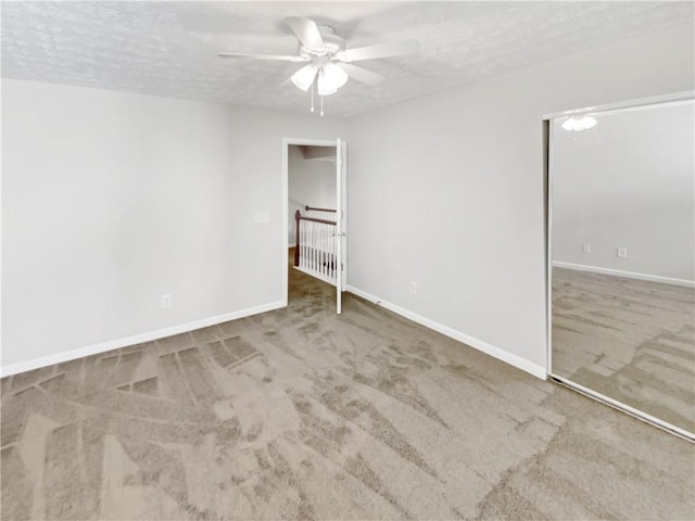 unfurnished room featuring ceiling fan, a textured ceiling, and carpet