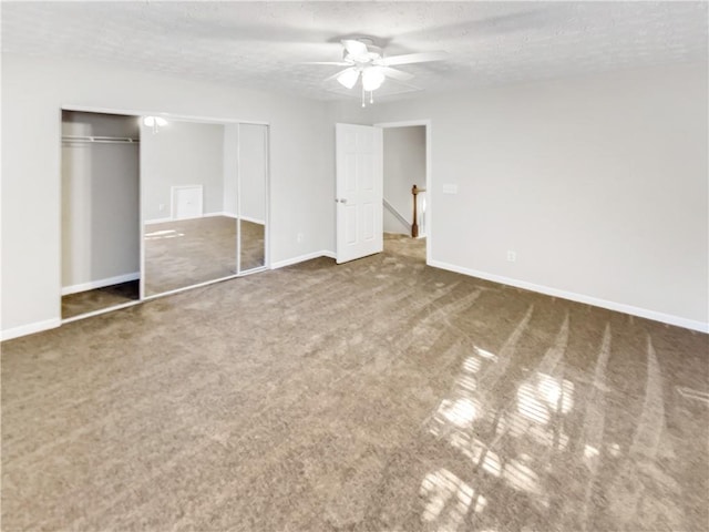 unfurnished bedroom featuring a textured ceiling, ceiling fan, a closet, and dark colored carpet