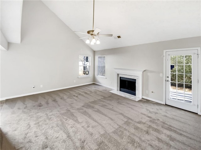 unfurnished living room with light carpet, ceiling fan, a fireplace, and high vaulted ceiling