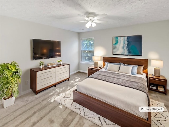 carpeted bedroom featuring ceiling fan and a textured ceiling