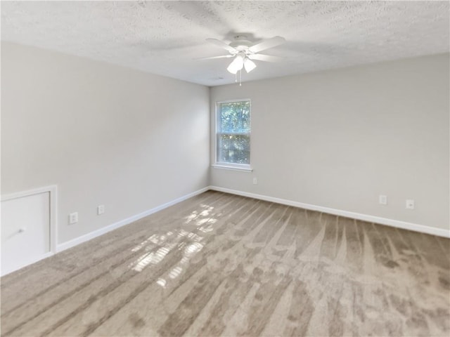 spare room with ceiling fan, a textured ceiling, and carpet flooring