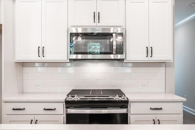 kitchen with appliances with stainless steel finishes, white cabinetry, and tasteful backsplash