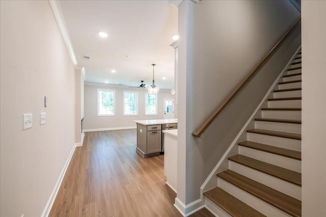 stairs featuring wood finished floors, baseboards, crown molding, and recessed lighting