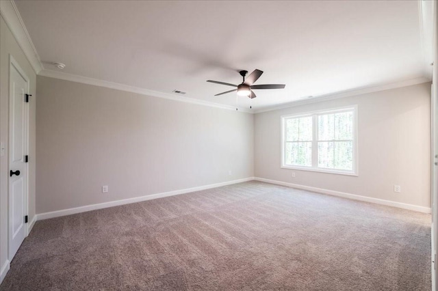carpeted empty room with ornamental molding, ceiling fan, baseboards, and a smoke detector