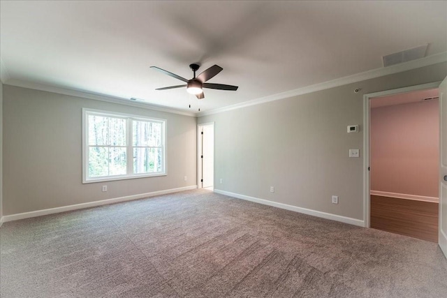 carpeted empty room featuring crown molding, ceiling fan, and baseboards