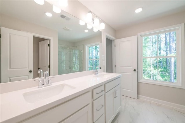 bathroom featuring a shower stall, baseboards, double vanity, marble look tile flooring, and recessed lighting