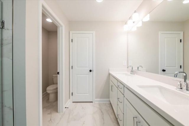 bathroom featuring marble finish flooring, toilet, double vanity, and baseboards