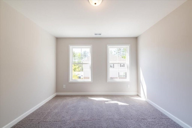 carpeted spare room featuring baseboards