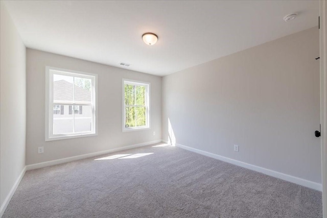 unfurnished room with carpet flooring and baseboards
