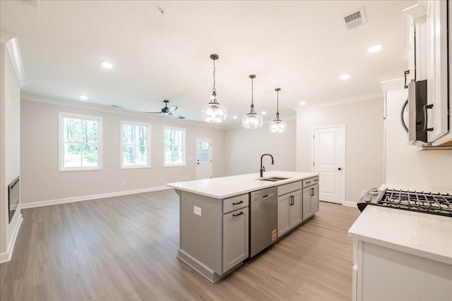 kitchen featuring stainless steel appliances, a sink, gray cabinets, ornamental molding, and ceiling fan