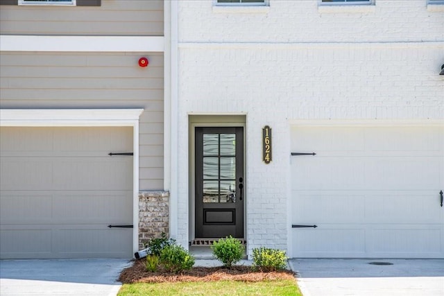 doorway to property with a garage and driveway