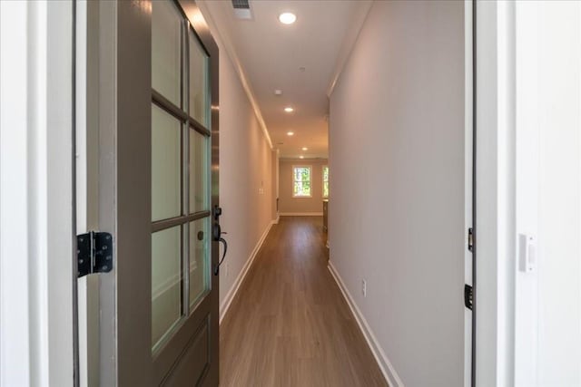 hall featuring wood finished floors, baseboards, and recessed lighting