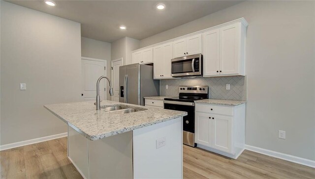 kitchen featuring white cabinets, appliances with stainless steel finishes, and a kitchen island with sink