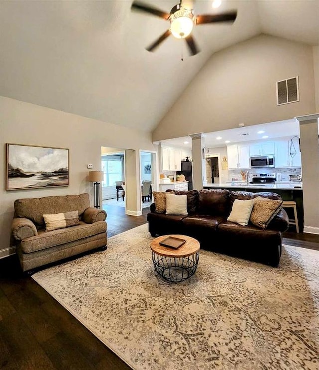 living room featuring ceiling fan, dark hardwood / wood-style flooring, and high vaulted ceiling