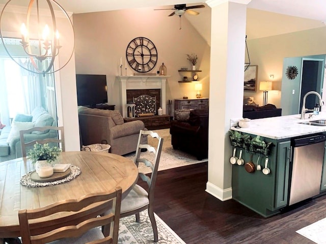 dining space featuring ceiling fan with notable chandelier, dark hardwood / wood-style flooring, vaulted ceiling, and sink