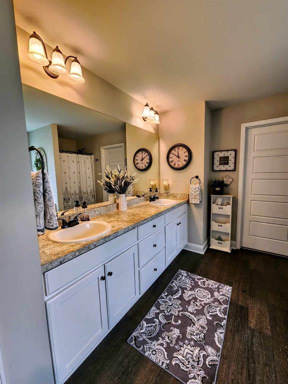 bathroom featuring vanity, wood-type flooring, and walk in shower