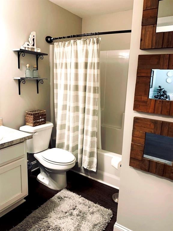 full bathroom featuring shower / bath combo with shower curtain, vanity, hardwood / wood-style floors, and toilet