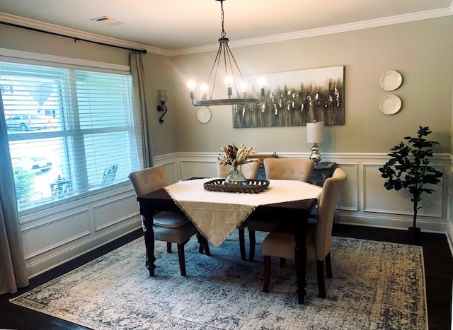 dining space with dark hardwood / wood-style flooring, crown molding, and a wealth of natural light