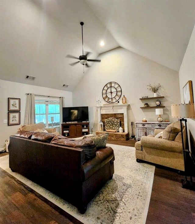 living room featuring ceiling fan, a fireplace, high vaulted ceiling, and dark wood-type flooring