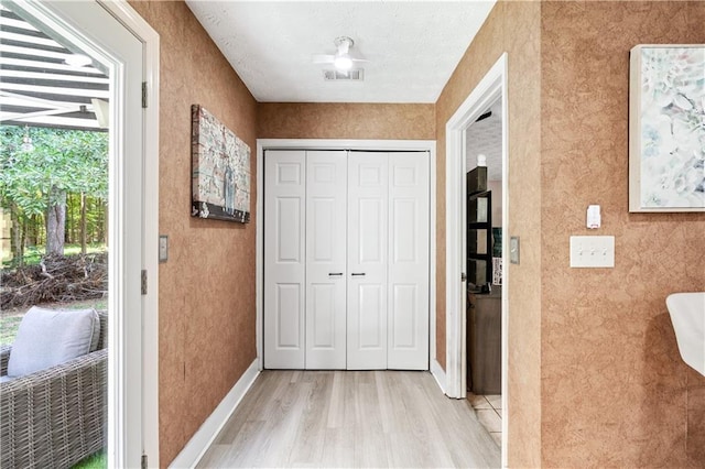 corridor with light hardwood / wood-style floors