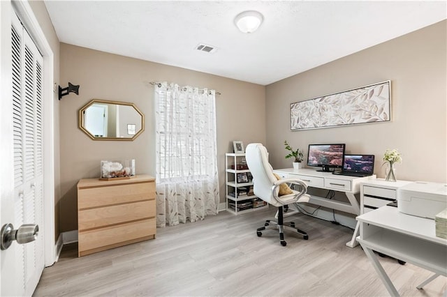 office with a wealth of natural light and light hardwood / wood-style flooring