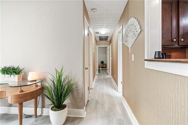 corridor with light hardwood / wood-style flooring