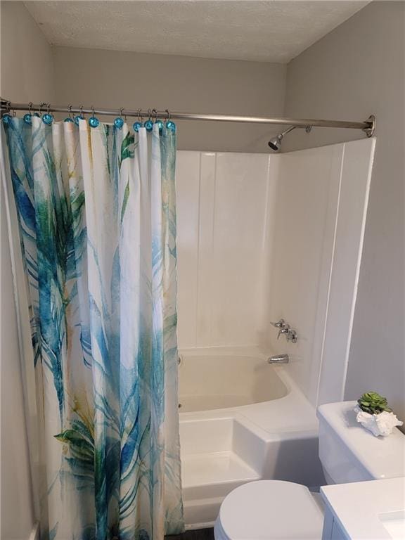 full bathroom featuring vanity, shower / tub combo, a textured ceiling, and toilet