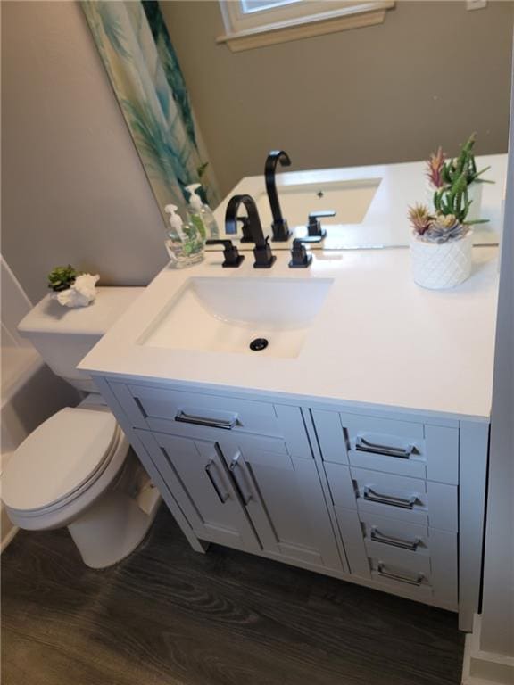 bathroom featuring hardwood / wood-style flooring, vanity, and toilet