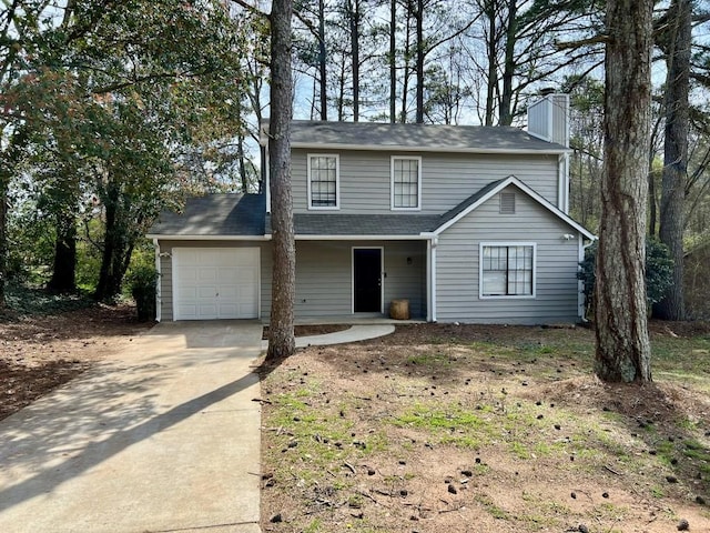 traditional-style home featuring a garage, concrete driveway, and a chimney