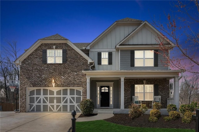 view of front of house with brick siding, board and batten siding, concrete driveway, covered porch, and an attached garage