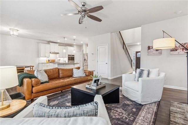 living area with a ceiling fan, dark wood finished floors, recessed lighting, baseboards, and stairs