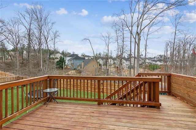 wooden terrace with a residential view and a yard