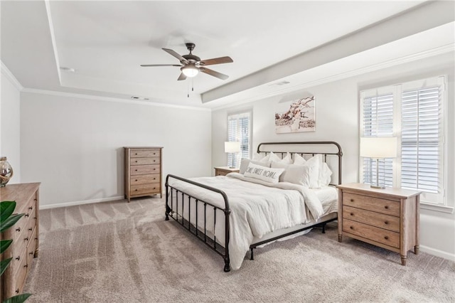 bedroom with a ceiling fan, baseboards, crown molding, a raised ceiling, and light colored carpet